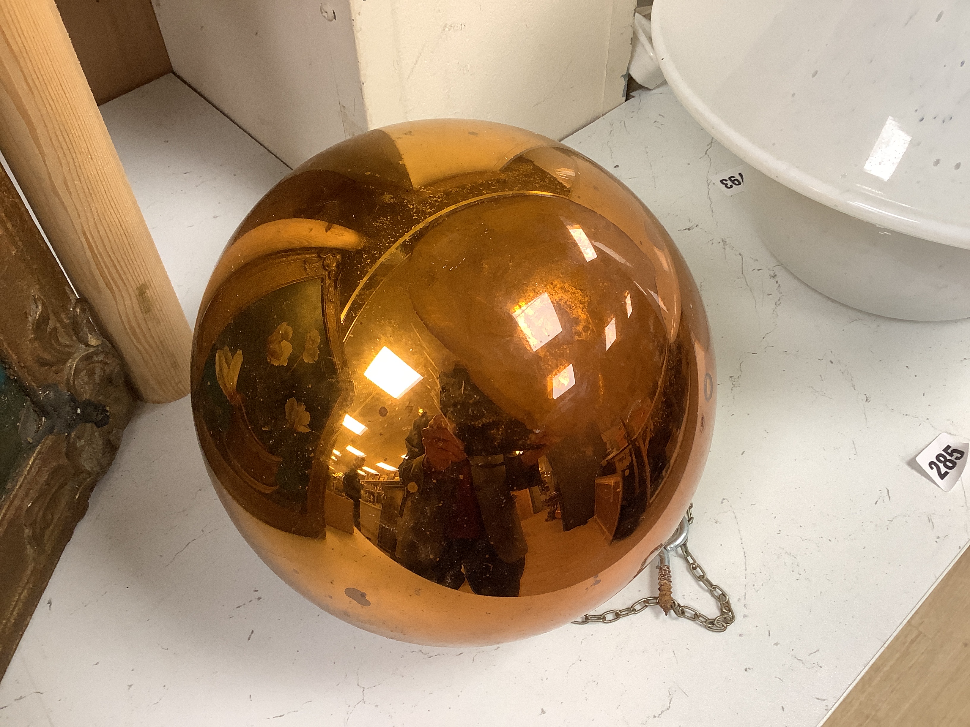A gold witch’s ball and three small witch’s balls (silver, red and blue)